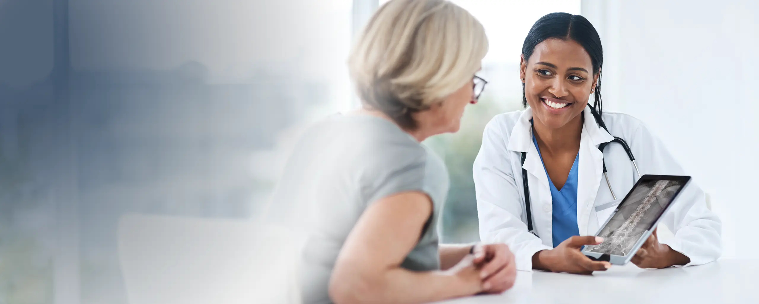 Arzt bespricht digitale Röntgenbilder mit einem Patienten in einer Praxis