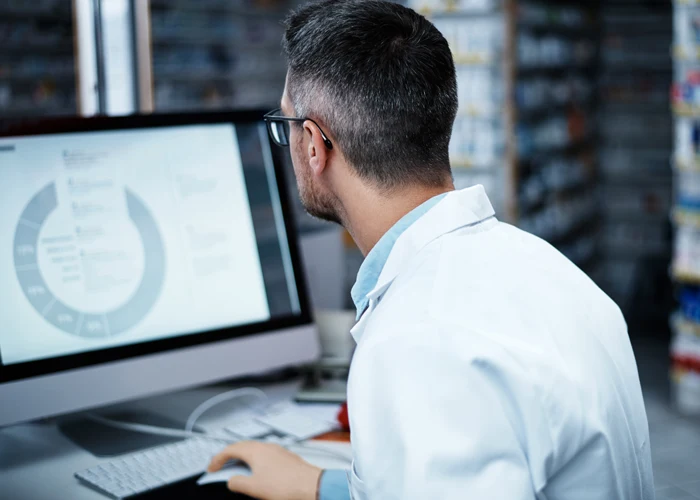 A veterinarian sitting in front of screen and watching a calculation